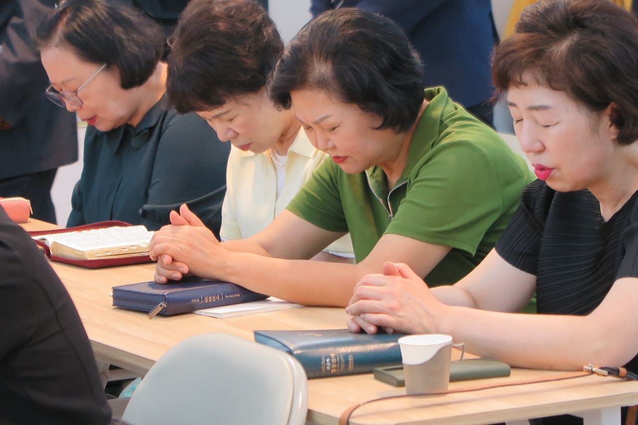 성경을 펴놓고 함께 기도하는 제자 여전도회 성도들